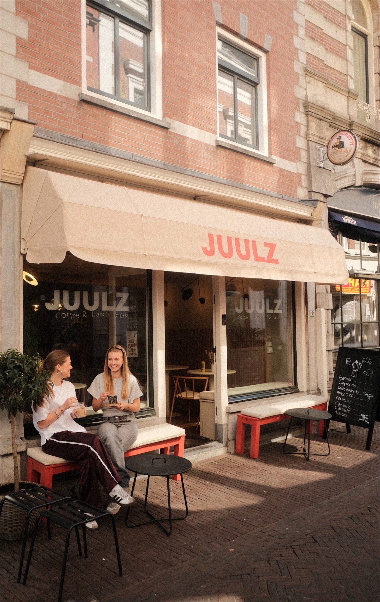 Two people drinking coffee outside at JUULZ